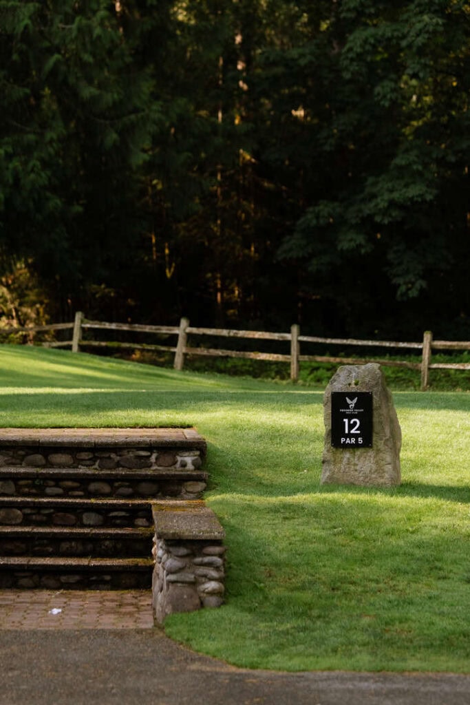 Golf course hole 12 marker with scenic mountain views in the background.